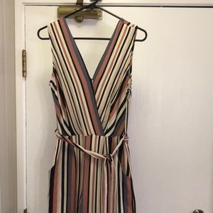 Striped jumpsuit. Ties across the waist. Has pockets and wide leg material.